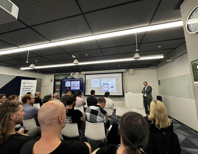 Audience watching a presentation on e-commerce and AI integration with commercetools branding