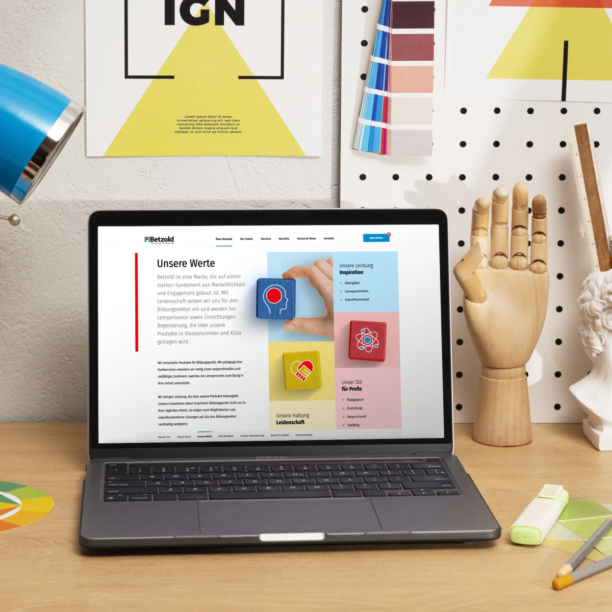 Betzold e-commerce website preview on a laptop showcasing the "Unsere Werte" (Our Values) corporate page within a creative office environment