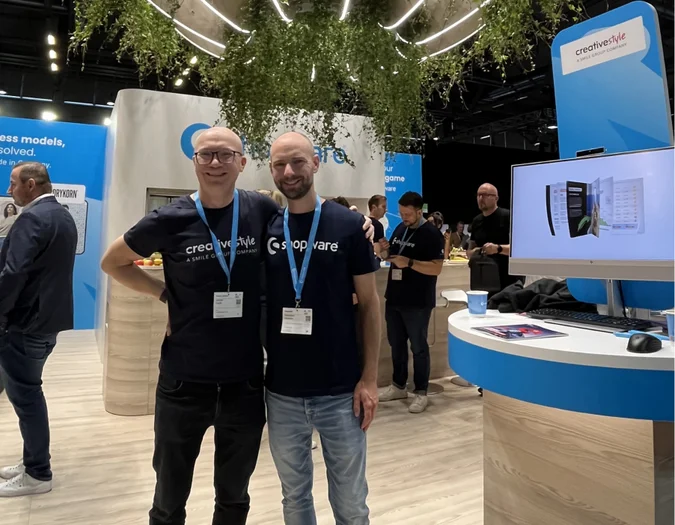 CEO Jaromir and a colleague posing together at a Shopware trade show booth with creative style branding