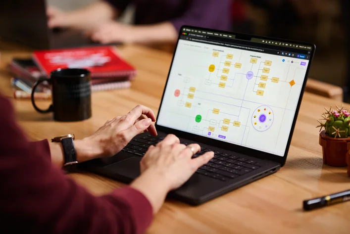 Designer working on information architecture and user navigation on laptop