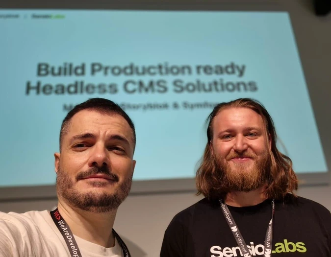 Two men posing in front of a presentation slide about Headless CMS solutions
