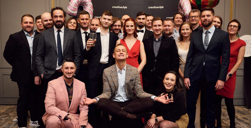 Large group of team members posing at a creative style Christmas party with festive decorations