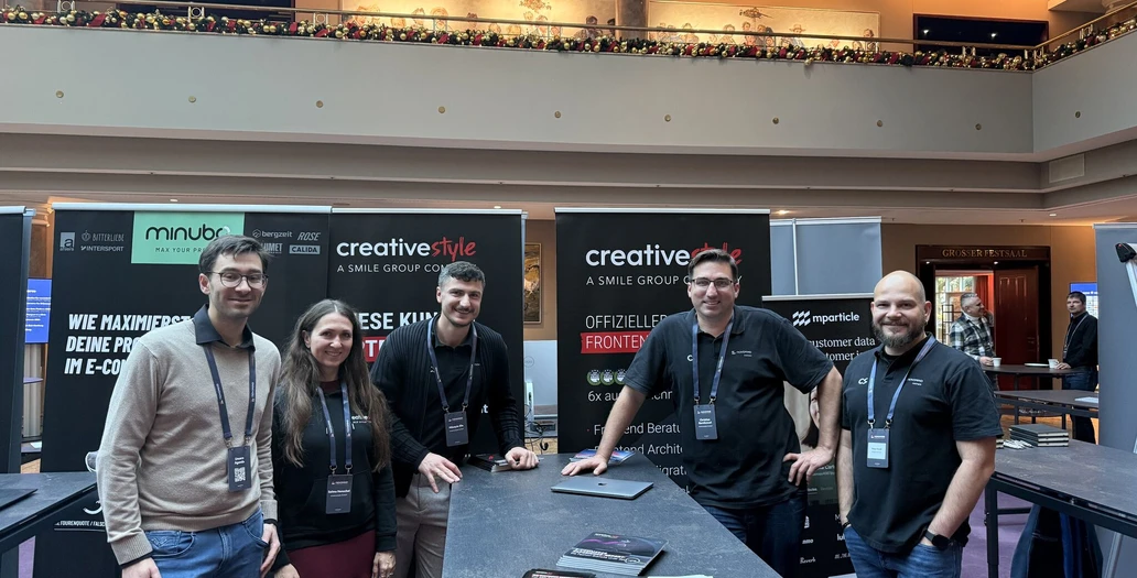 Five team members posing at a trade show booth with creative style, minubo, and mparticle branding